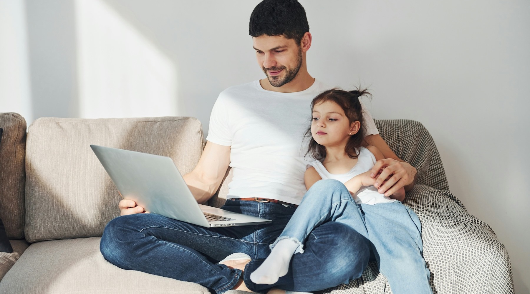 a man and his daughter looking at a laptop